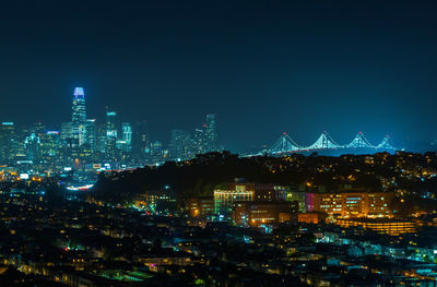 Illuminated buildings in city against sky at night