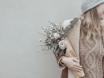 Midsection of woman standing against wall