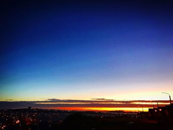 Silhouette buildings against blue sky at sunset