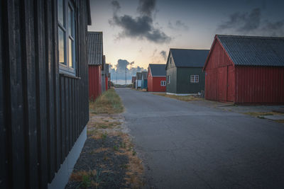 Empty road amidst buildings against sky