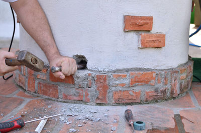 Making a hole in a concrete by hands with hammer and chisel