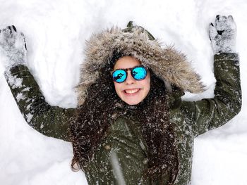 Portrait of young woman playing in snow