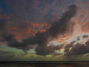 Scenic view of sea against dramatic sky during sunset