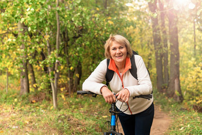 Portrait of a smiling young woman in forest