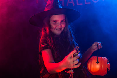 Young woman holding sparkler at night