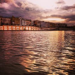 View of river against cloudy sky at dusk