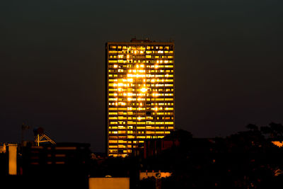 Low angle view of illuminated buildings against sky at night