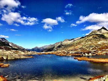 Scenic view of lake and mountains against blue sky