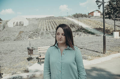 Portrait of beautiful young woman standing on land