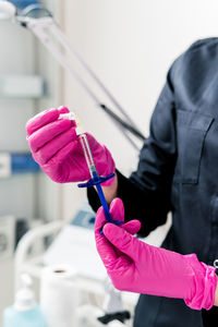 Midsection of scientist examining chemical in laboratory