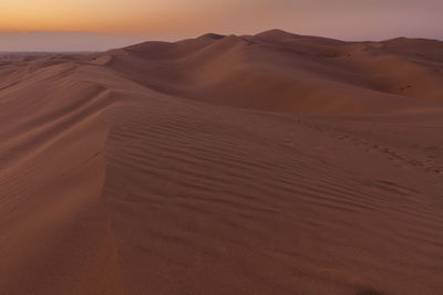 Scenic view of desert against sky during sunset