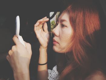 Close-up of woman holding mirror