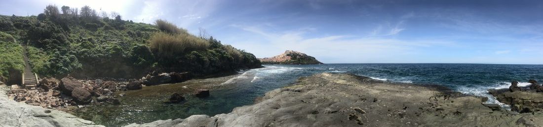 Panoramic shot of rocks on beach against sky