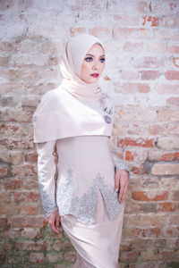 Portrait of young woman standing against brick wall