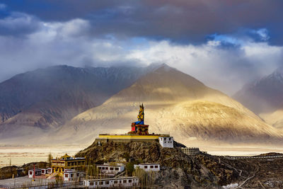 Traditional windmill on mountain against sky