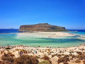 Scenic view of beach against clear blue sky