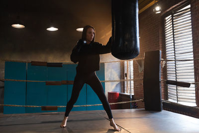 Full length of woman exercising in gym