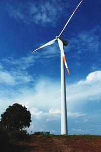 Low angle view of windmill on field against sky