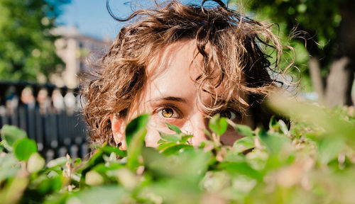 Eyes of a girl behind the green hedge