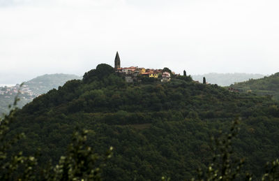 Castle by buildings against sky