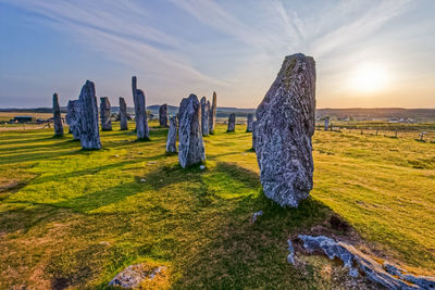 View of rocks on landscape against sky during sunset