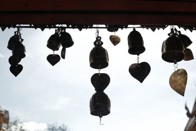 Low angle view of lanterns hanging by building against sky