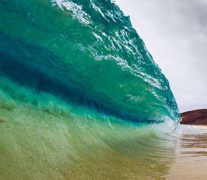 Scenic view of wave at sea against sky