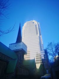 Low angle view of modern buildings against clear blue sky