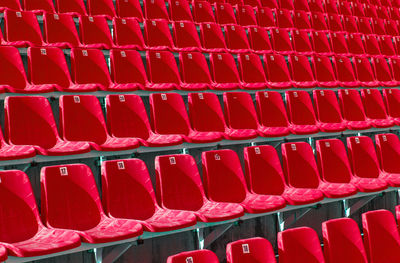 Folded red plastic chairs on a temporary tribune. selective focus