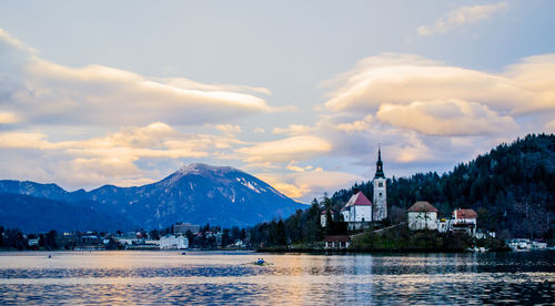 Panoramic view of buildings by mountains against sky during winter