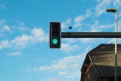 Low angle view of road signal against blue sky