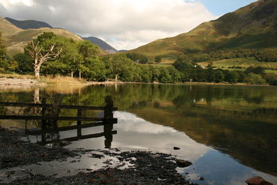 Scenic view of calm lake against cloudy sky