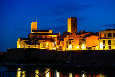 Illuminated buildings against blue sky