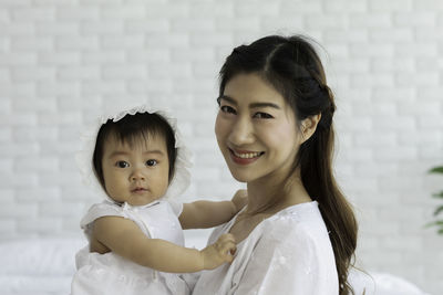 Portrait of cheerful mother with daughter at home