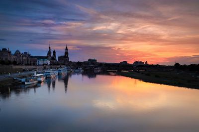 Panoramic view of canal and buildings against sky during sunset