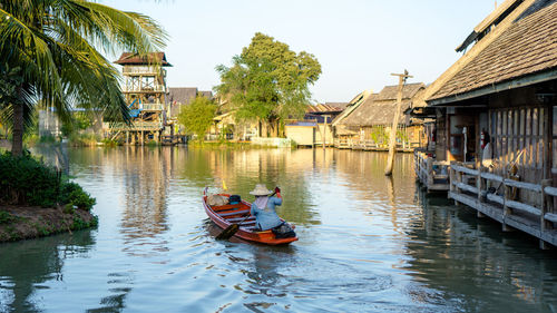 Rear view of man rowing boat in canal