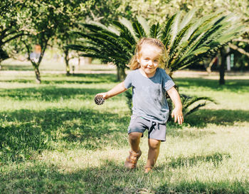 Full length of smiling boy on grassy field