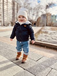 Portrait of boy walking on footpath