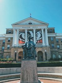 Low angle view of statue against building against clear sky