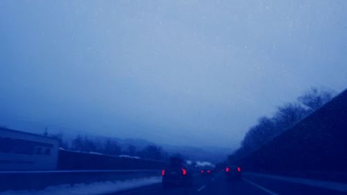 Cars on road against sky during winter