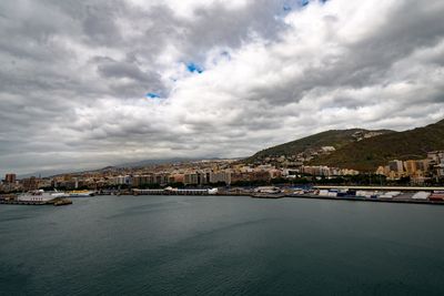 Scenic view of sea by townscape against sky