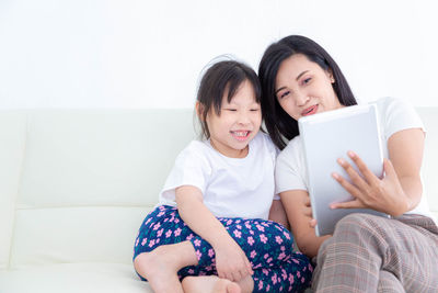 Happy friends sitting on sofa