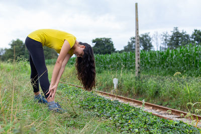 Rear view of woman standing on grassy field