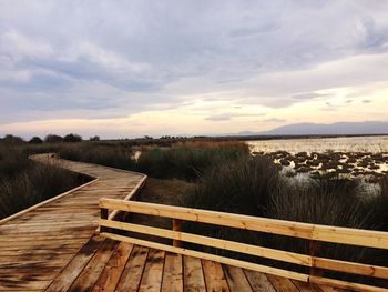 View of boardwalk against sky during sunset