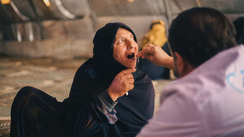 An elderly woman receives medical care at a makeshift medical clinic inside a syrian refugee camp.