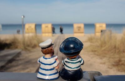 Sailors figurine on retaining wall at beach