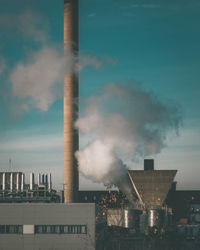 Smoke emitting from chimney against sky