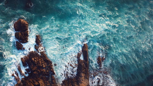 High angle view of wave splashing on rock