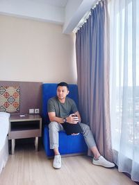 Young man sitting on sofa at home