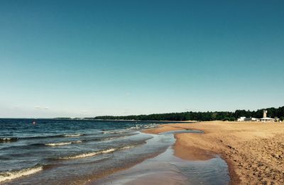 Scenic view of beach against clear blue sky